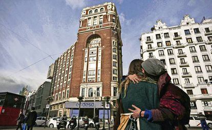 Dos mujeres se abrazan delante del Palacio de la Prensa.