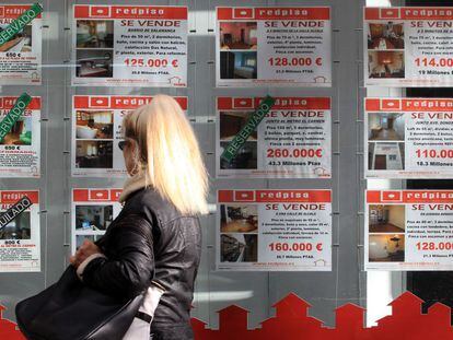 Carteles con pisos en venta en una oficina inmobiliaria en Madrid. 