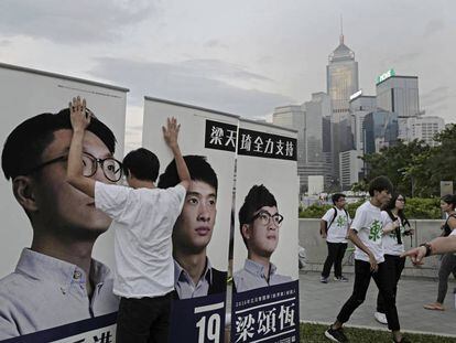 Un ciudadano sujeta varios carteles electorales en Hong Kong.