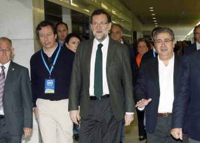 El jefe del Ejecutivo, Mariano Rajoy (c), llega al Palacio de Congresos de El Toyo en la capital almeriense, acompañado por el presidente del PP-A, Juan Ignacio Zoido (d) y el vicesecretario del partido Carlos Floriano (2-i), donde ha clausurado hoy la reunión intermunicipal del PP.