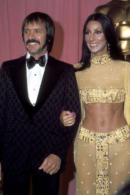 ¿Quiénes son? Cher y Sonny Bono. ¿Cuándo brillaron en la alfombra? La pareja y dúo pop acudieron a la gala en 1973 para entregar la estatuilla a mejor canción del año, con la californiana luciendo un icónico crop top de manga larga y falda estilo egipcio de Bob Mackie que ha homenajeado hasta la propia Kim Kardashian. ¿Cuánto duró su romance? Solo un año después actuaron juntos por última vez y en 1975 firmaron el divorcio.