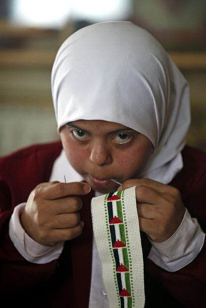 Una niña borda en una cinta banderas palestinas en el Centro Right to Live que acoge a menores con deficiencias psíquicas en Gaza