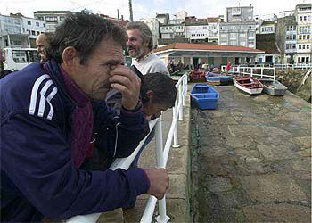 Dos pescadores muestran su preocupación en el puerto de Finisterre ante la pérdida económica que supone la marea negra.