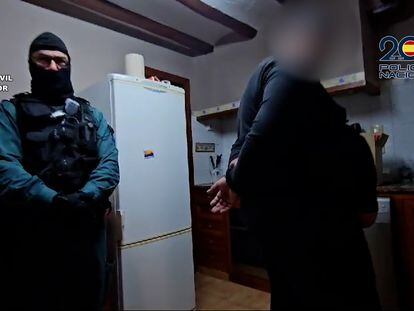 Un guardia civil custodia a un detenido en la Operación Napoleón-Aguazul que ha permitido desmantelar una red de trata de seres humanos en una imagen facilitada por Interior.