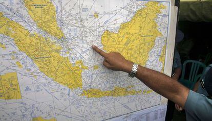 Un oficial assenyala en un mapa el lloc probable de l'accident.