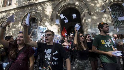 Varios estudiantes salen de la Universidad de Barcelona con papeletas.
