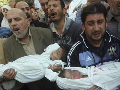 Palestinos sostienen los cad&aacute;veres de dos ni&ntilde;os durante su funeral.