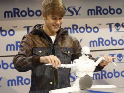 El cantante Justin Bieber presenta un robot en la feria CES de Las vegas.