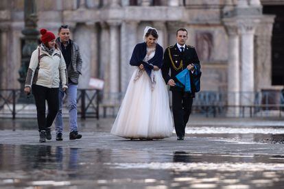 Una pareja de recién casados ​​camina por una plaza inundada el 14 de noviembre en Venecia.