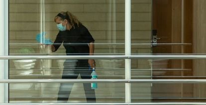 Una trabajadora desinfecta una zona de paso de un hotel.
