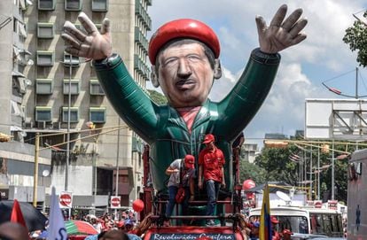 Seguidores del presidente venezolano, Nicolás Maduro, portan un inflable gigante de Chaves en Caracas, este martes.