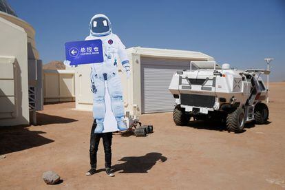 El proyecto ha sido llevado a cabo por la compañía C-Space que cuenta con el apoyo de las autoridades locales y del Centro de Astronautas de China. En la imagen, un miembro del personal coloca un letrero con la forma de traje espacial en la base de simulación de Marte.
