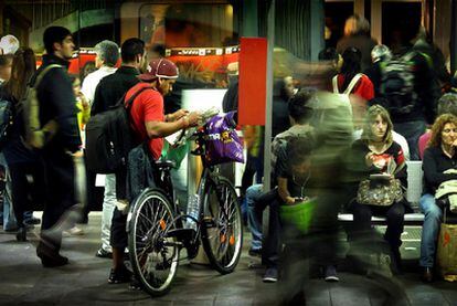 Un ciclista accede a un tren de Rodalies con su bicicleta en la plaza de Catalunya.