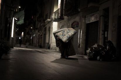 Un hombre arrastra colchones en Barcelona. 