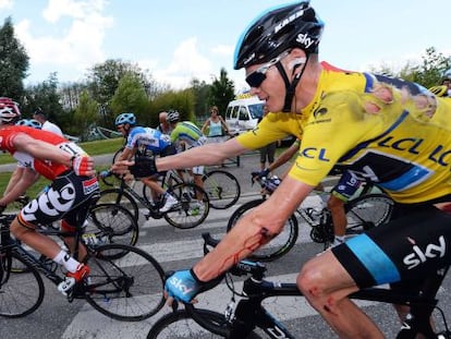 El británico Chris Froome tiende la mano al belga Jurgen Van den Broeck, tras su caída de este viernes.