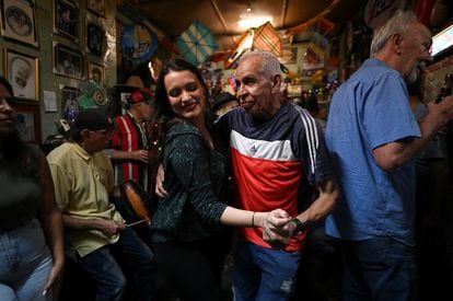 Personas bailan durante un recorrido de ocho horas organizado por distintos bares y restaurantes para mejorar sus ventas, el 30 de diciembre.
