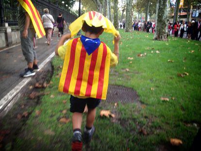 Un niño se protege de la lluvia en Barcelona y retrasa el acto oficial en el Parc de la Ciutadella.