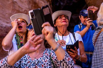 Excited tourists photograph the facade of Petra.