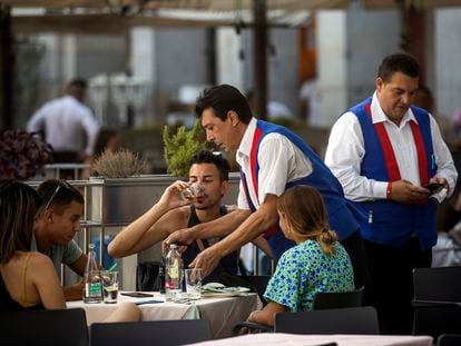 Camareros atienden a los clientes en una terraza del centro de Madrid, la primera semana de agosto.