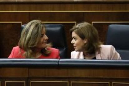 La vicepresidenta del Gobierno, Soraya Sáenz de Santamaría (d), conversa con la ministra de Empleo, Fátima Báñez (i).