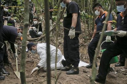 Un equipo de la polic&iacute;a forense malasia excava una fosa descubierta en las colinas Wang Burma al norte del pa&iacute;s. 