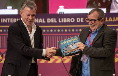 Juan Manuel Santos expresidente de Colombia le entrega de regalo el libro 'En un mismo barco' al exlíder de las FARC Rodrigo Londo, alias Timochenko.
