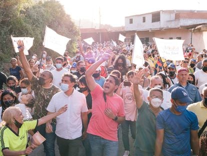 El candidato por la Mesa de la Unidad, José Manuel Olivares, saluda a unos simpatizantes mientras camina junto al excandidato a la gobernación de Miranda, Carlos Ocariz,  en La Guaira, Venezuela, el 14 de noviembre.