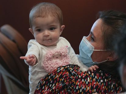 La pequeña Emma, de 13 meses, en brazos de su madre, Ana, hoy en el hospital público madrileño de La Paz.