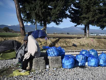 Un refugiado, cubierto con una mata, espera en el puesto fronterizo de Idomeni (Grecia) poder cruzar a Macedonia, el 30 de noviembre de 2015.