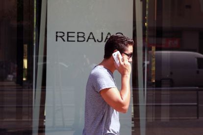 Un joven habla con su móvil en una calle de Madrid.
