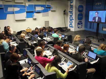 Periodistas atienden una intervención del presidente del Gobierno Mariano Rajoy a través de una pantalla de plasma en la sala de prensa del PP en 2013.