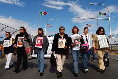 Familiares y amigos de las mujeres asesinadas en Ciudad Juárez ( México) llevan las fotos de éstas en una manifestación para pedir a las autoridades que encuentren a los autores.