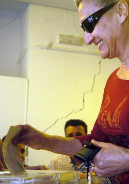 Una mujer deposita su voto en un colegio electoral de Lorca, dañado por el seismo.