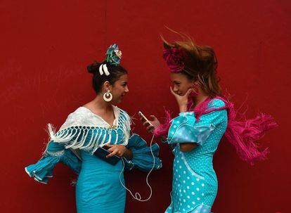 TOPSHOT - Two girls wearing traditional Sevillian dresses talk during the "Feria de Abril" (April Fair) in Sevilla on April 30, 2017. 
The fair dates back to 1847 when it was originally organized as a livestock fair but has turned into a week of flamenco dancing, music and bullfighting.  / AFP PHOTO / CRISTINA QUICLER