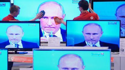 Empleados de una tienda limpian una pantalla de televisi&oacute;n durante una intervenci&oacute;n televisiva del presidente Vlad&iacute;mir Putin, el jueves en Mosc&uacute;.