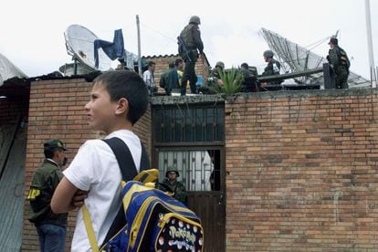 Un niño observa a fuerzas especiales, después de que estallara una bomba cerca de la sede de la policía, Bogotá, el 22 de octubre de 2002.