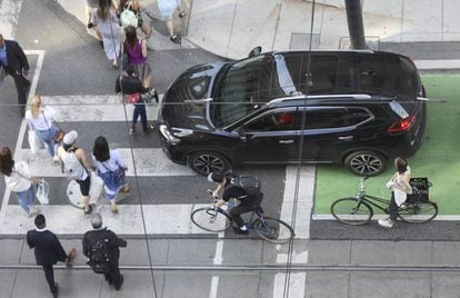 Una calle de Toronto (Canada) con peatones, ciclistas y coches.