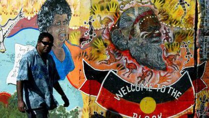 Un aborigen australiano pasa por delante de un mural de arte ind&iacute;gena en Redfern, un barrio perif&eacute;rico de Sidney. 