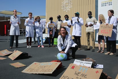Un trabajador médico realiza una "respiración artificial" simbólica en un globo terráqueo durante una protesta por el efecto del cambio climático en cuestiones de salud en la Cumbre del Clima de la ONU COP27, el viernes 11 de noviembre de 2022, en Sharm el-Sheij, Egipto.