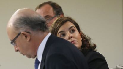 Soraya Sáenz de Santamaría, amb els ministres d'Hisenda, Cristóbal Montoro , i Sanitat, Alfonso Alonso (darrere), durant la roda de premsa posterior a la reunió del Consell de Ministres celebrada al Palau de la Moncloa.