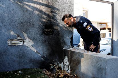 Un policía israelí observa el lugar en el que cayó uno de los proyectiles, en la ciudad de Sderot.
