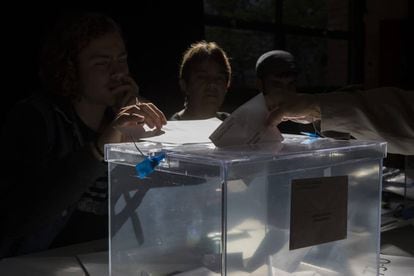 Una papeleta es introducida en una urna del colegio electoral La Sedeta, en Barcelona.