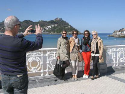 Un grupo de turistas se hace fotos en el donostiarra Paseo de la Concha.