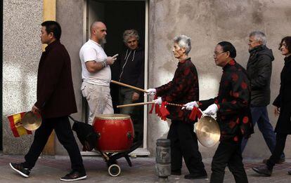 Un grupo de chinos desfila por el barrio de Usera para celebrar el Año de la Cabra, ante la mirada de otros vecinos.