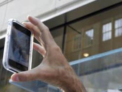 Usuarios del iPhone toman imágenes con sus móviles.