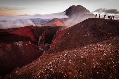 Cráter rojo característico del macizo de Tongariro, en Nueva Zelanda, con el monte Ngauruhoe al fondo.