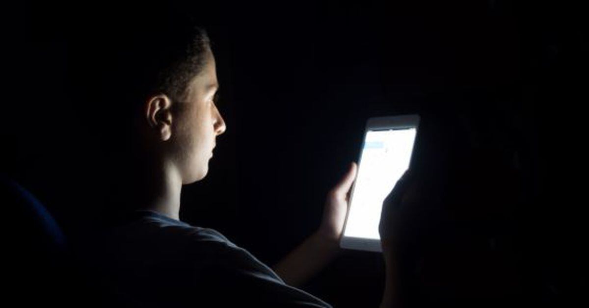 Ночью включается телефон. Чтение в темноте. Человек перед компьютером в темноте. Экран телефона в темноте. Экран для чтения в темноте.