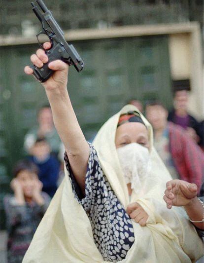 Una mujer armada celebra la victoria de Liamín Zerual en las elecciones presidenciales de 1995.
