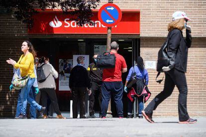 Varios clientes esperan su turno para entrar en una oficina bancaria. EFE/Fernando Villar/Archivo