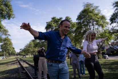 La influenciadora 'La Mona Guisa' y Alejandro Eder caminan sobre las vías férreas durante un recorrido en Cali.